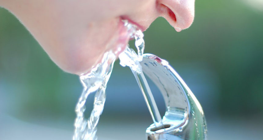 woman drinking from water fountain