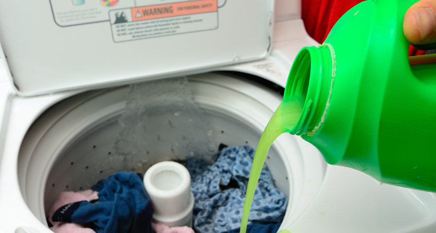 person pouring detergent into washing machine
