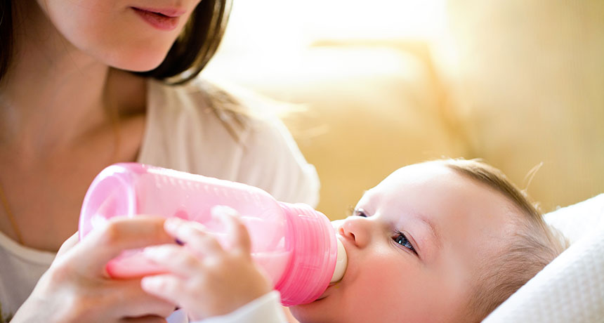 woman feeding baby a bottle