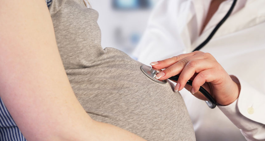 stethoscope on a pregnant woman's belly