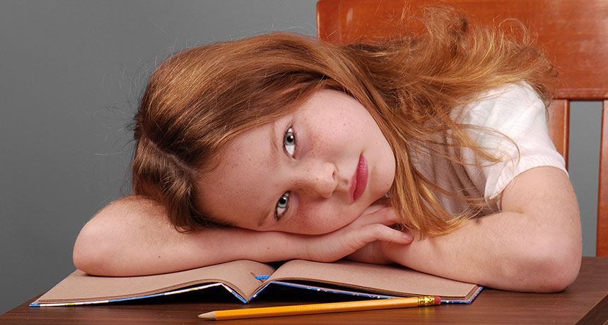 girl with her head down on book