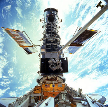 a photo of two astronauts replacing Hubble's broken gyroscopes