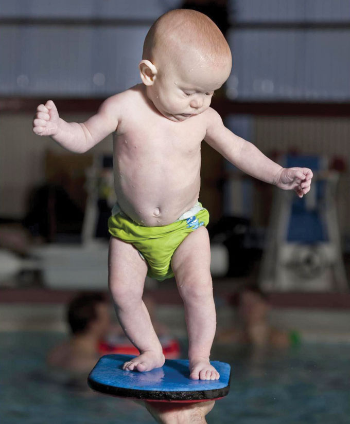 baby standing on kickboard