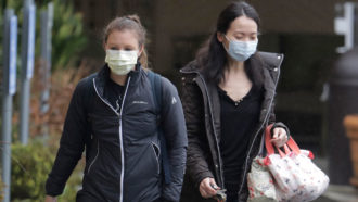 two women wearing masks