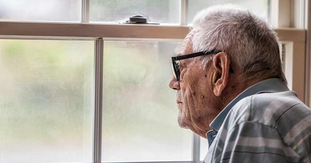 elderly man looking out window