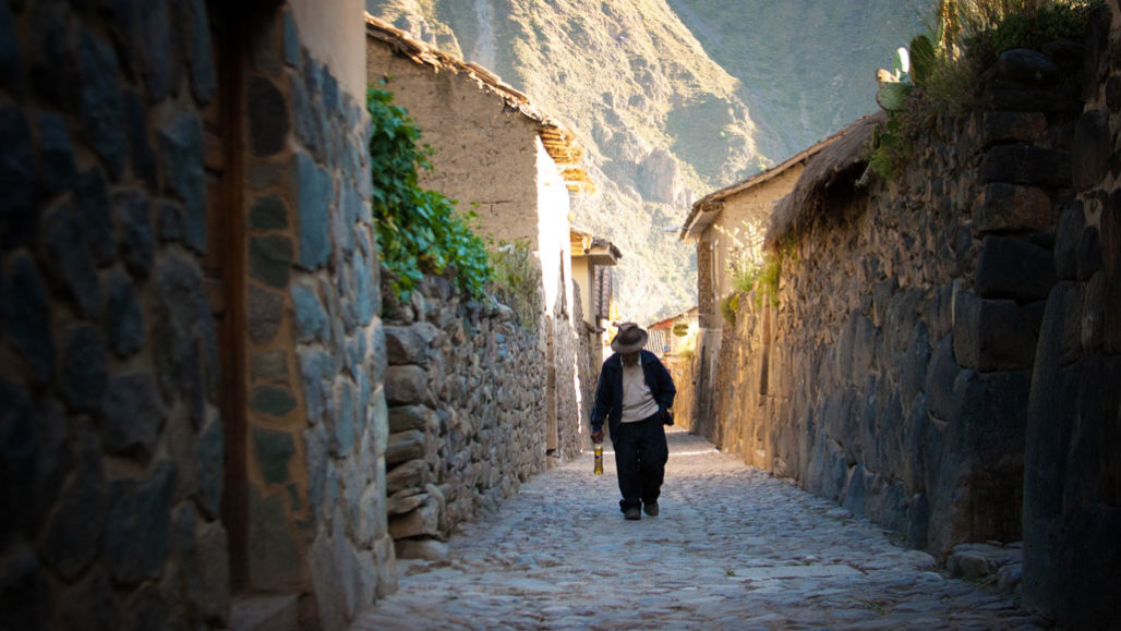 Peruvian man walking up cobblestone path