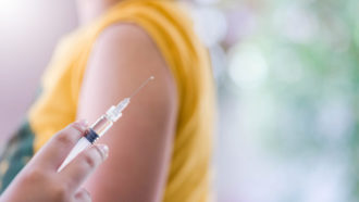 photograph of someone about to get a vaccine shot