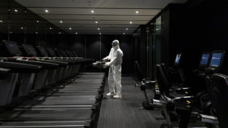 Worker spraying disinfectant in a fitness center