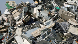 huge pile of discarded keyboards, computers and more