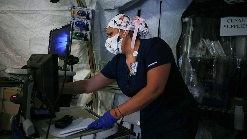 medical professional wearing a mask working in a tent