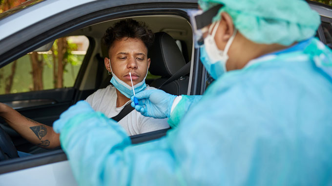 person in car getting a nasal swab for a COVID test