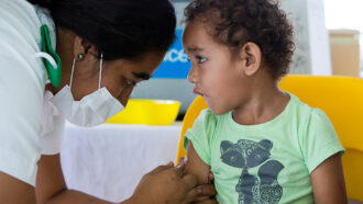 child in Samoa getting measles vaccine