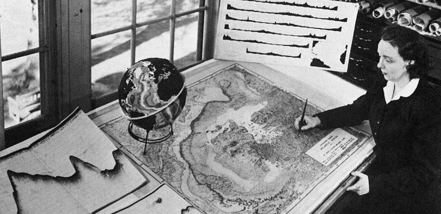 Marie Tharp looks over a map on a table