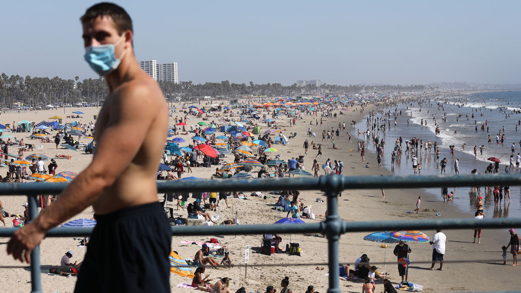 man met masker op het strand van Santa Monica