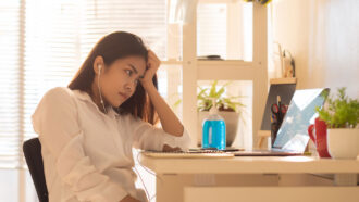 woman looking bored at a laptop