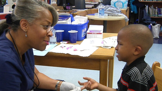 nurse drawing blood from a boy in Flint, Michigan