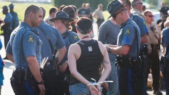 demonstrators being detained by police officers in Ferguson