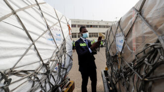 worker checking a vaccine shipment