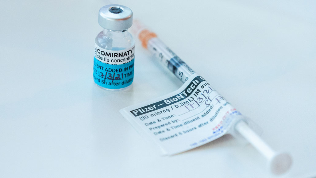 vial and syringe containing pfizer covid-19 vaccine