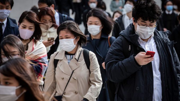 crowd of Japanese commuters wearing masks
