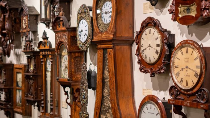 a wall of old-fashioned clocks