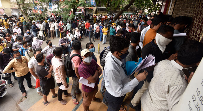 people waiting in lines outside a pharmacy in Pune