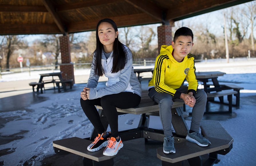 a 14-year-old girl and 12-year-old boy sitting on a picnic table