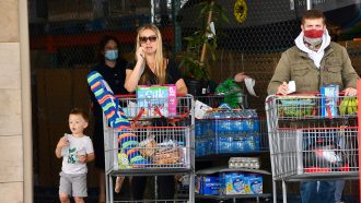 woman and child at grocery store not wearing masks with man wearing mask