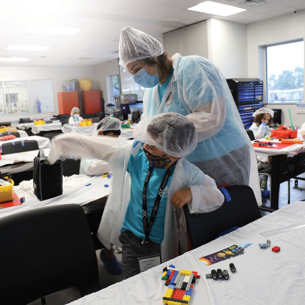 kids wearing protective gear in a cleanroom