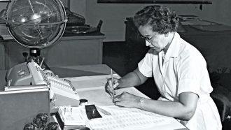 black and white photo of Katherine Johnson sitting at a desk