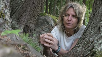 A woman with medium blond hair next to a tree