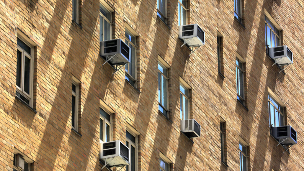 grid of window air conditioning units outside a Manhattan building