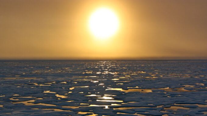 looking out over icy, flat terrain with sun in sky