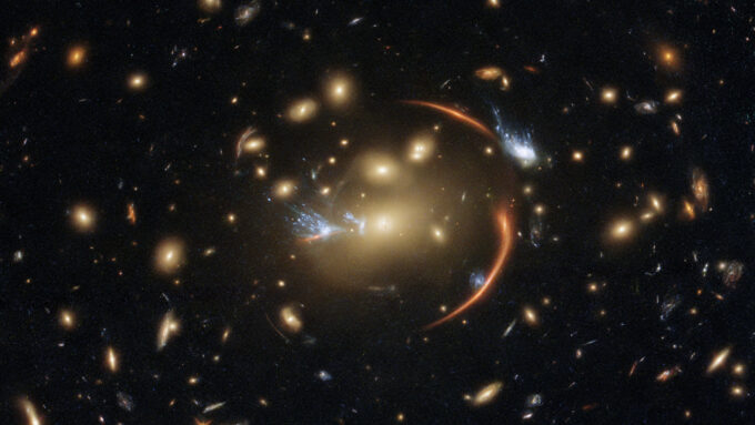 a black background highlights several galaxies, with a half-circle orange arc