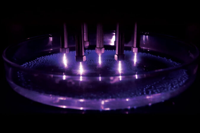 金属棒在紫光中向盛有水的盘子发射电荷