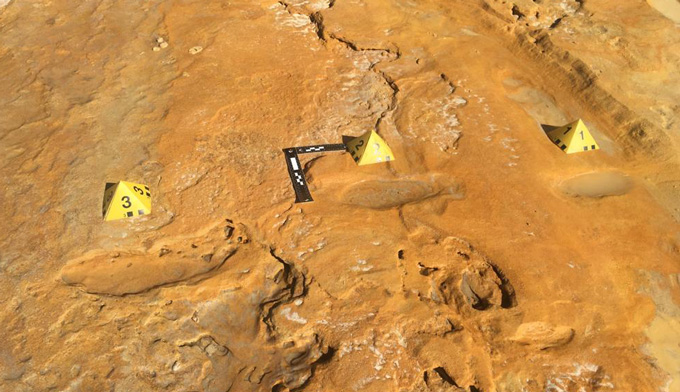 three fossilized neandertal footprints marked by yellow pyramids