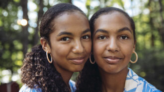 twin girls stand side by side