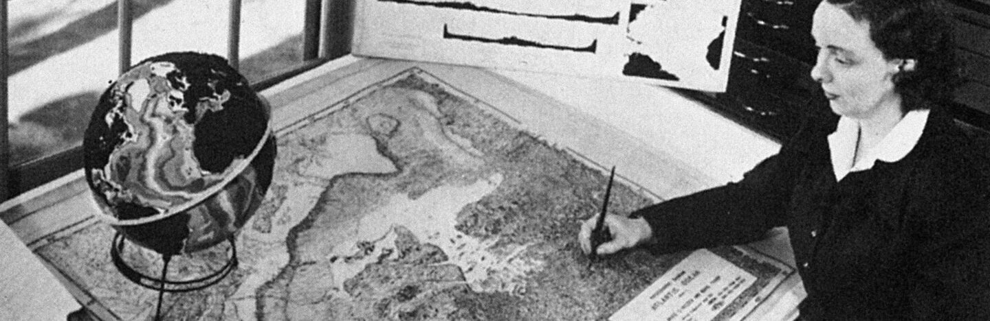 Marie Tharp at a desk drawing a map