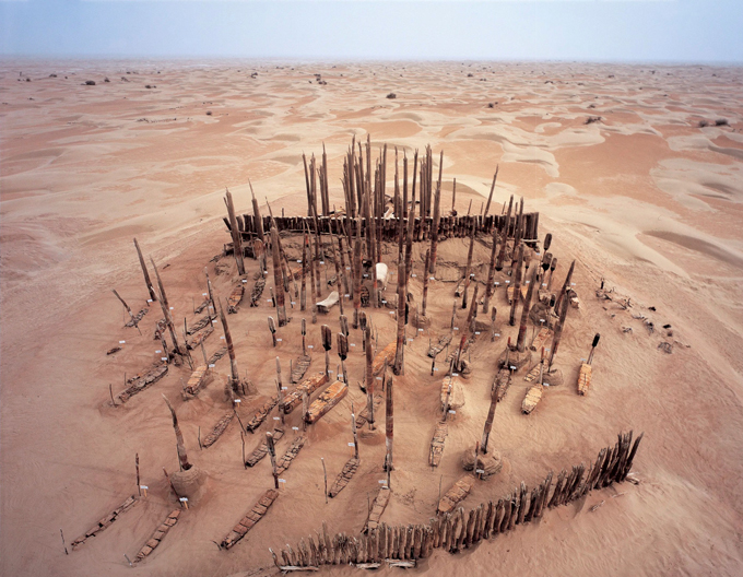 a cemetery in the desert with spiky protrusions pointing out from the sand in China's Tarim Basin