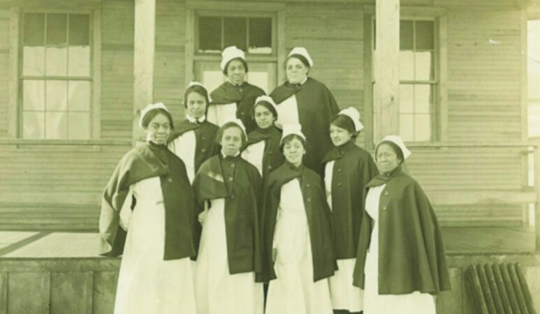 black and white historical photo of nine nurses, all of whom are Black