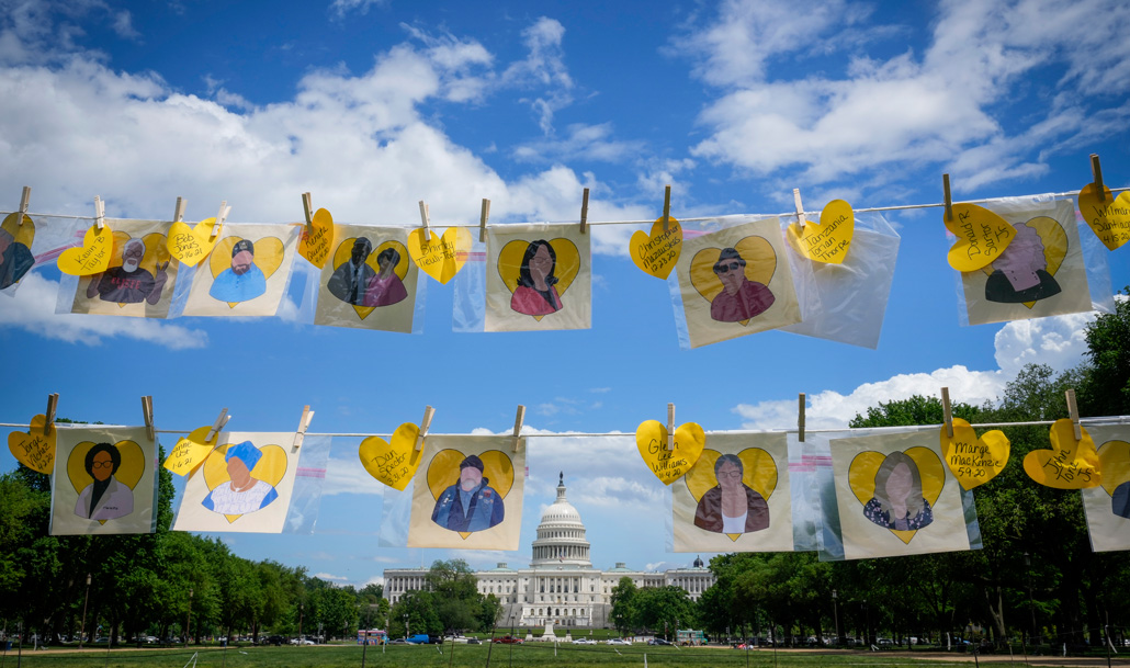 clothesline with drawings of people on them, with the U.S. Capitol in the background