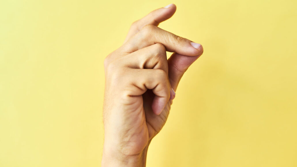 image of a hand snapping on a yellow backdrop