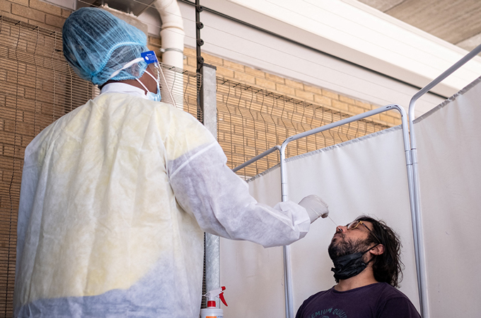 health care worker administering nasal COVID-19 test