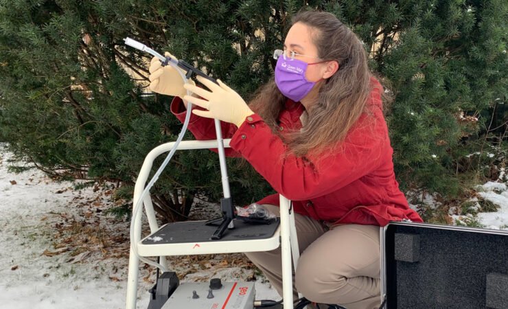 photo of Elizabeth Clare collecting air DNA samples with a pump