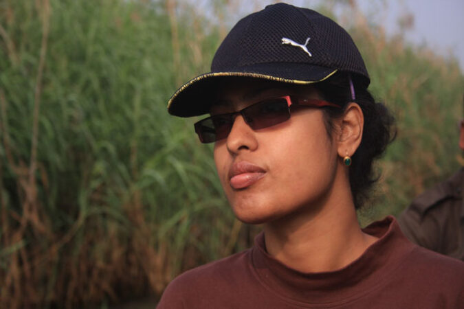 image of Tiasa Adhya wearing ball cap and sunglasses with marsh in the background
