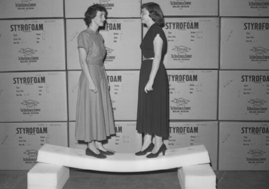 black and white image of two women standing on a piece of styrofoam