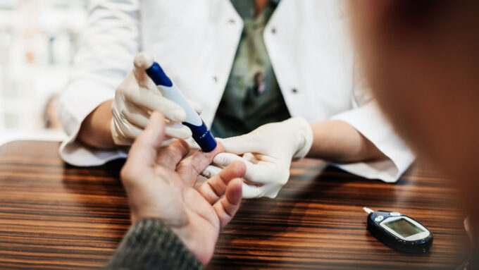 photo of someone pricking a finger to test blood sugar levels