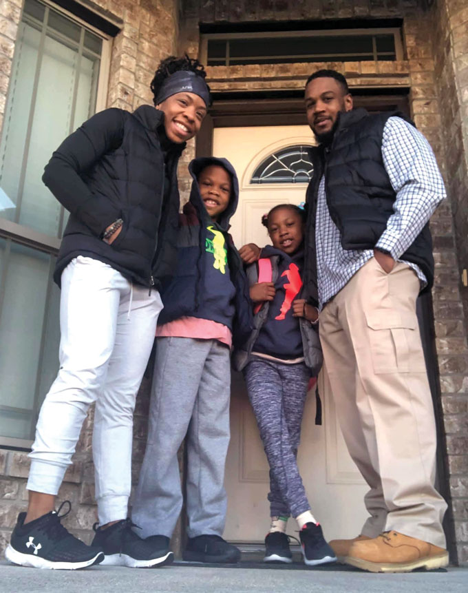 A photo of Amber Williams, and her family standing in an open doorway