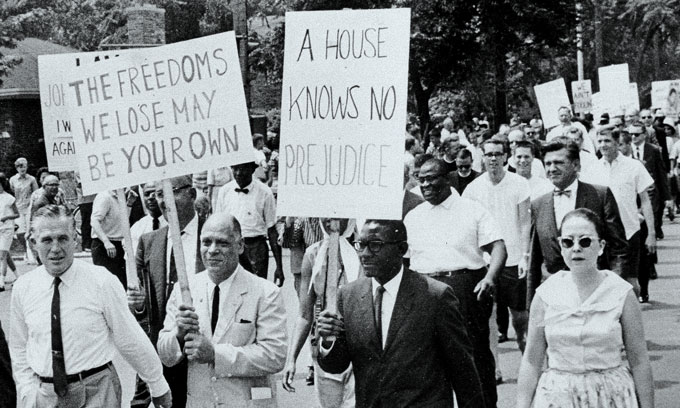 a photo of people marching at a 1963 anti-discrimination march, George Romney is on the far left of the picture