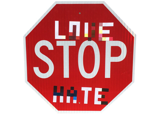 image of a stop sign with stickers that read "Love" and "Hate" above and below the word "Stop"